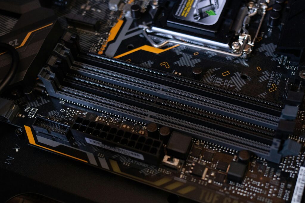 pexels-photo-2582932-2582932 Detailed view of a computer motherboard showcasing RAM slots and electronic components.